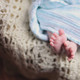 Babyfüße Nahaufnahme Babyfüße die aus einer blauen Decke schauen