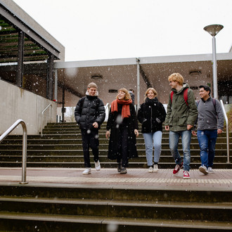 Studierende laufen über den Campus.