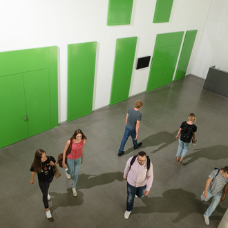Studierende laufen durch ein Gebäude.