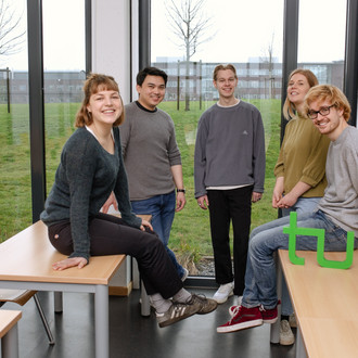 Ein Gruppenfoto von Studierenden im Seminarraum mit dem TU Dortmund Logo.