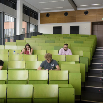 Vier Studierende sitzen im Hörsaal.