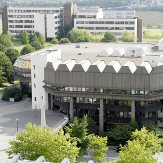 Vorne im Bild die Bibliothek der TU Dortmund und dahinter weitere hohe Gebäude.