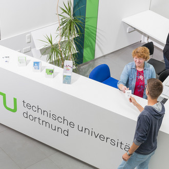 Ein Student gibt seine Wartenummer bei der Studienberatung ab.