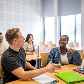 Studierende unterhalten sich im Seminarraum