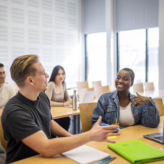 Studierende unterhalten sich im Seminarraum