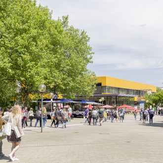 Campusleben mit Studierenden und Mensa im Hintergrund