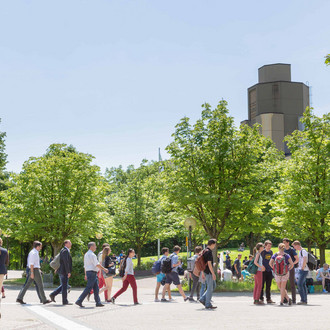 Menschen laufen über den Campus Nord.