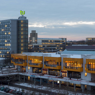 Mathetower und Mensa beleuchtet im Winter im Querformat