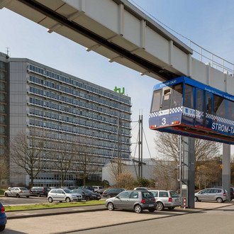 H-Bahn mit Mathetower im Hintergrund mit kahlen Bäumen