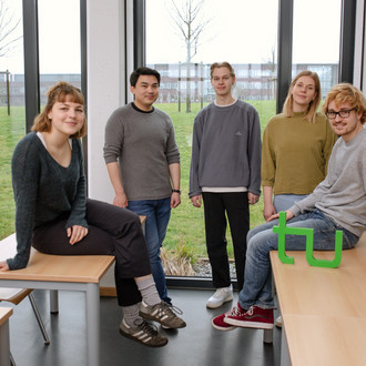 Ein Gruppenfoto von Studierenden im Seminarraum mit dem TU Dortmund Logo.