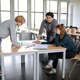 Drei Studierende bei einer Gruppenarbeit