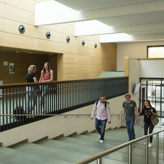 Studierende gehen eine Treppe hoch