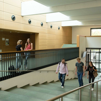 Studierende gehen eine Treppe hoch