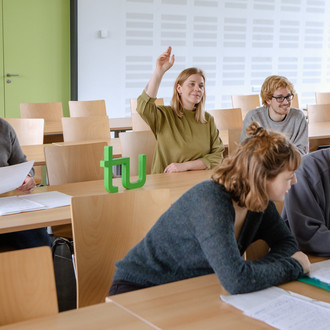 Studierende sitzen im Seminarraum und beteiligen sich am Seminar.