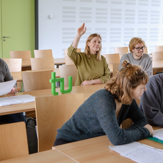 Studierende sitzen im Seminarraum und beteiligen sich am Seminar.