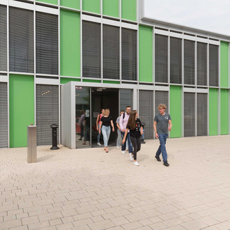 Studierende verlassen ein Gebäude.