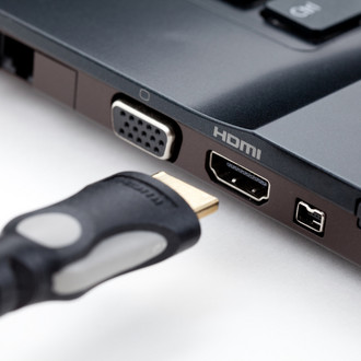 Nahaufnahme eines HDMI-Kabels und HDMI-Anschlusses an einem Laptop.