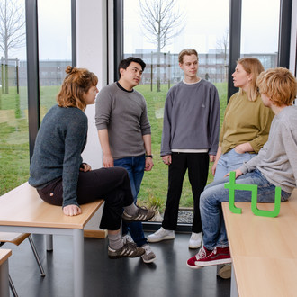 Ein Gruppenfoto von Studierenden im Seminarraum mit dem TU Dortmund Logo.