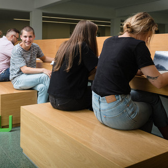 Eine Rückenansicht von sitzenden Studierenden.
