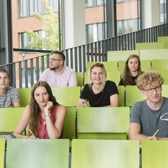 Eine Gruppe Studierender sitzt in einem Hörsaal.