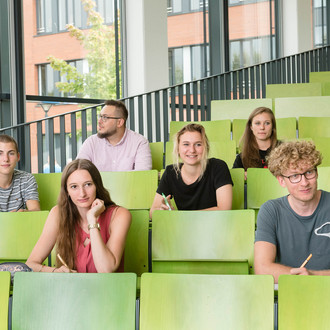 Eine Gruppe Studierender sitzt in einem Hörsaal.