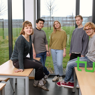 Ein Gruppenfoto von Studierenden im Seminarraum mit dem TU Dortmund Logo.