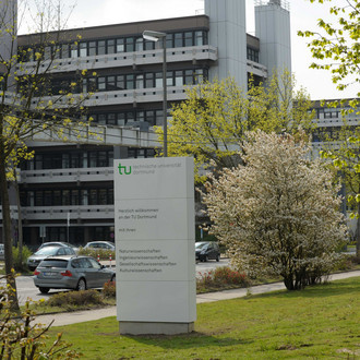 Das Gebäude an der Emil-Figge-Straße 50 mit einer Stele im Vordergrund.
