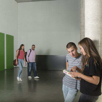 Zwei Studierende unterhalten sich, zwei andere kommen auf sie zu.