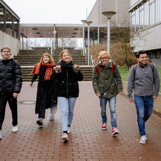 Studierende laufen über den Campus.