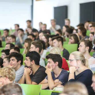 Studierende sitzen in einer Vorlesung im Hörsaal.