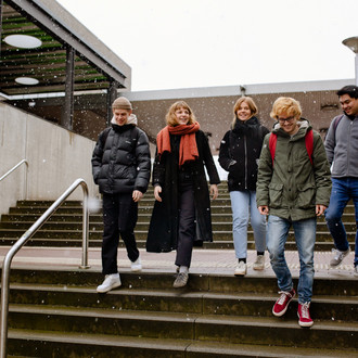 Studierende laufen über den Campus.
